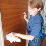 ドアノブをふく女性